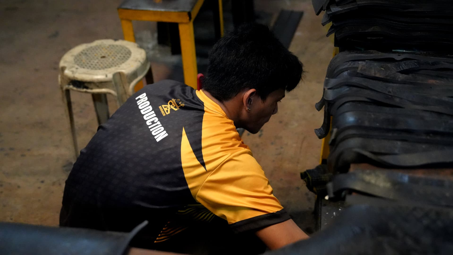 Worker inspecting freshly molded rubber sheet stock used for anti-vibration pads